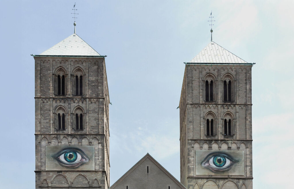 Fotografie der Skulptur "Auge für Auge" der Künstlerin Pascale Feitner an den Türmen des St.-Paulus-Doms in Münster